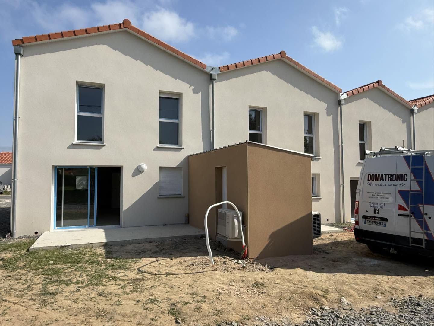 Unité extérieure de climatisation au pied d’une maison neuve